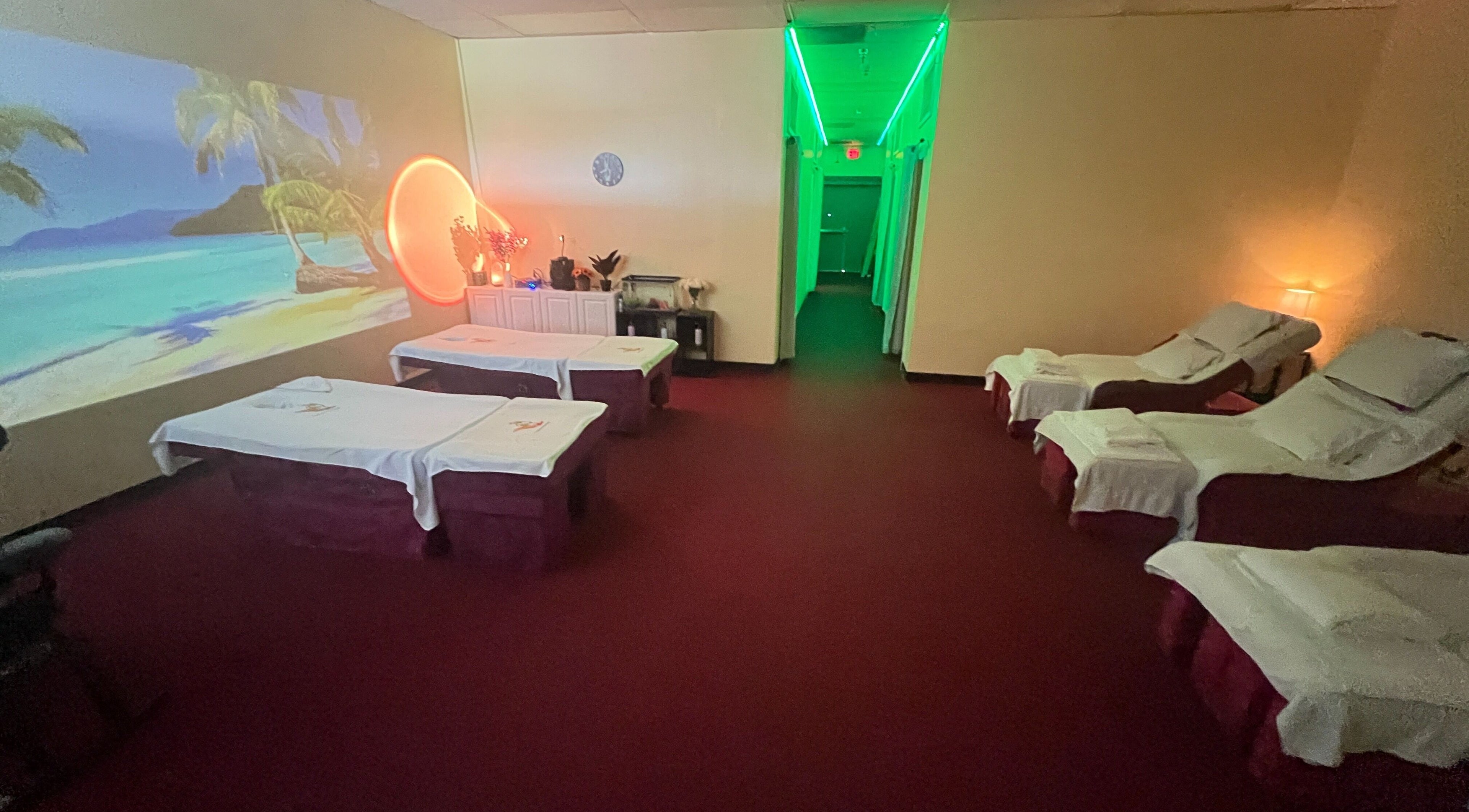 Relaxing massage room at Ten Toes Reflexology, Lawrence, Kansas, US with soothing ocean mural and ambient lighting.