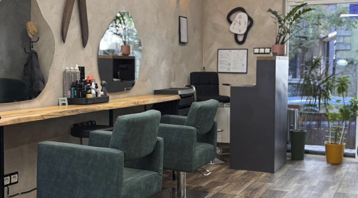 Интериор на КОСЪМ- Hair & Nails в София, Област София, BG с елегантни зелени кресла и огледала.