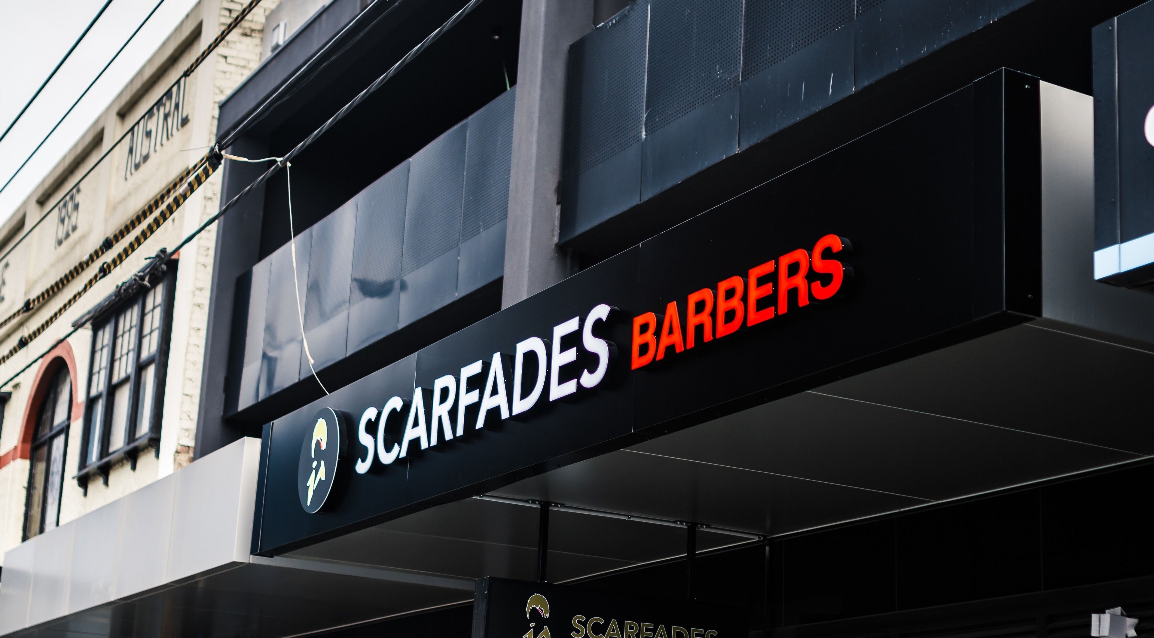 Scarfades Barbers shop sign in Melbourne, Victoria, AU showcases modern design and vibrant colors.