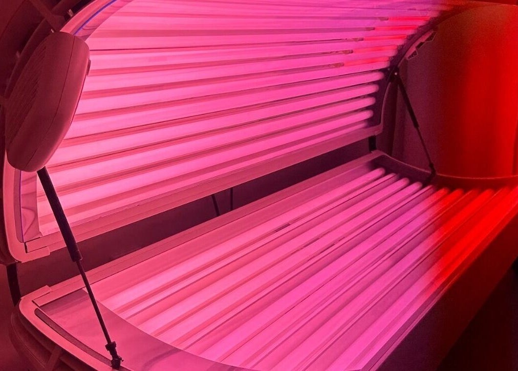 Glow Szn tanning bed in Condell Park, New South Wales, AU with vibrant pink lighting.