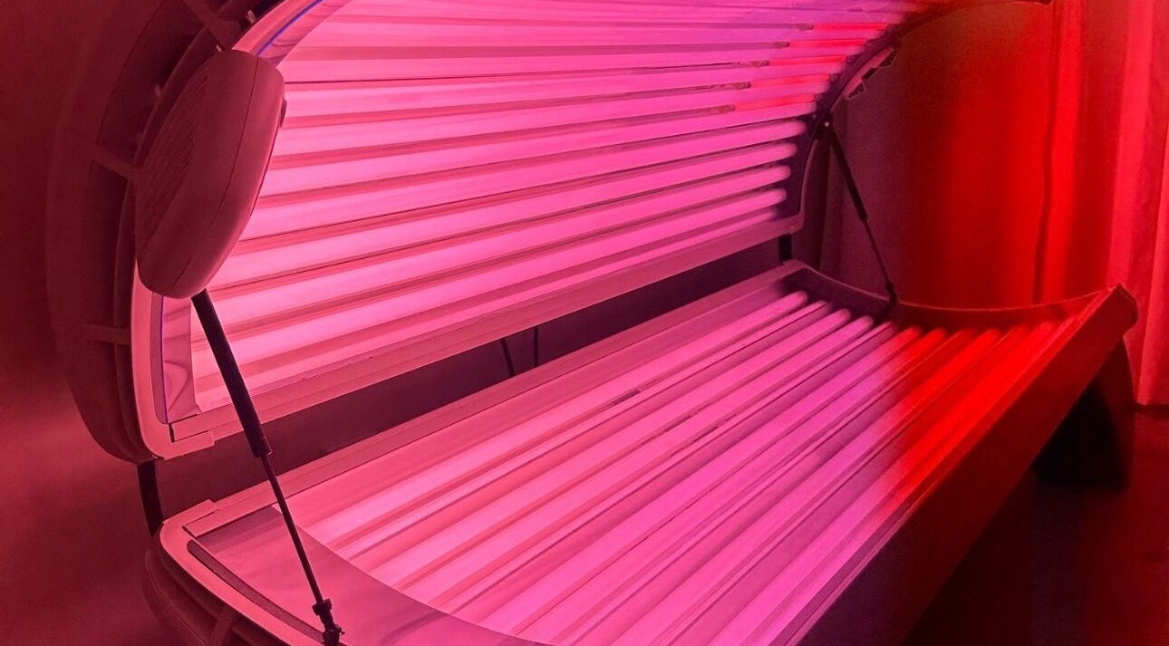 Glow Szn tanning bed in Condell Park, New South Wales, AU with vibrant pink lighting.
