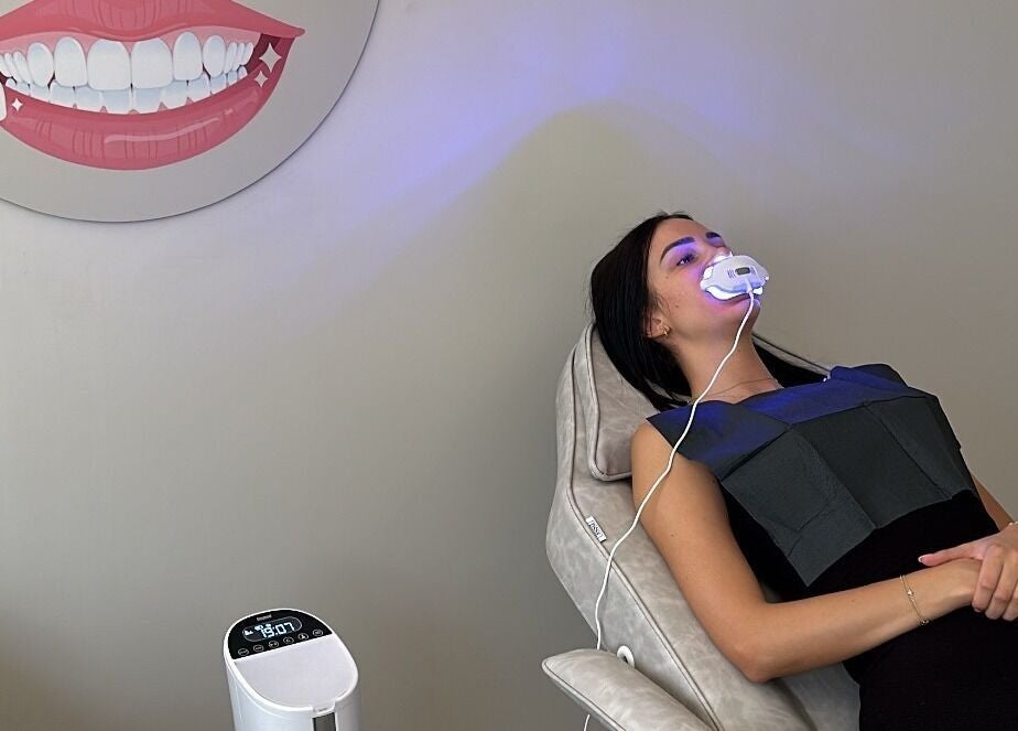 Client receiving a teeth whitening treatment at Glow Szn in Condell Park, New South Wales, AU.