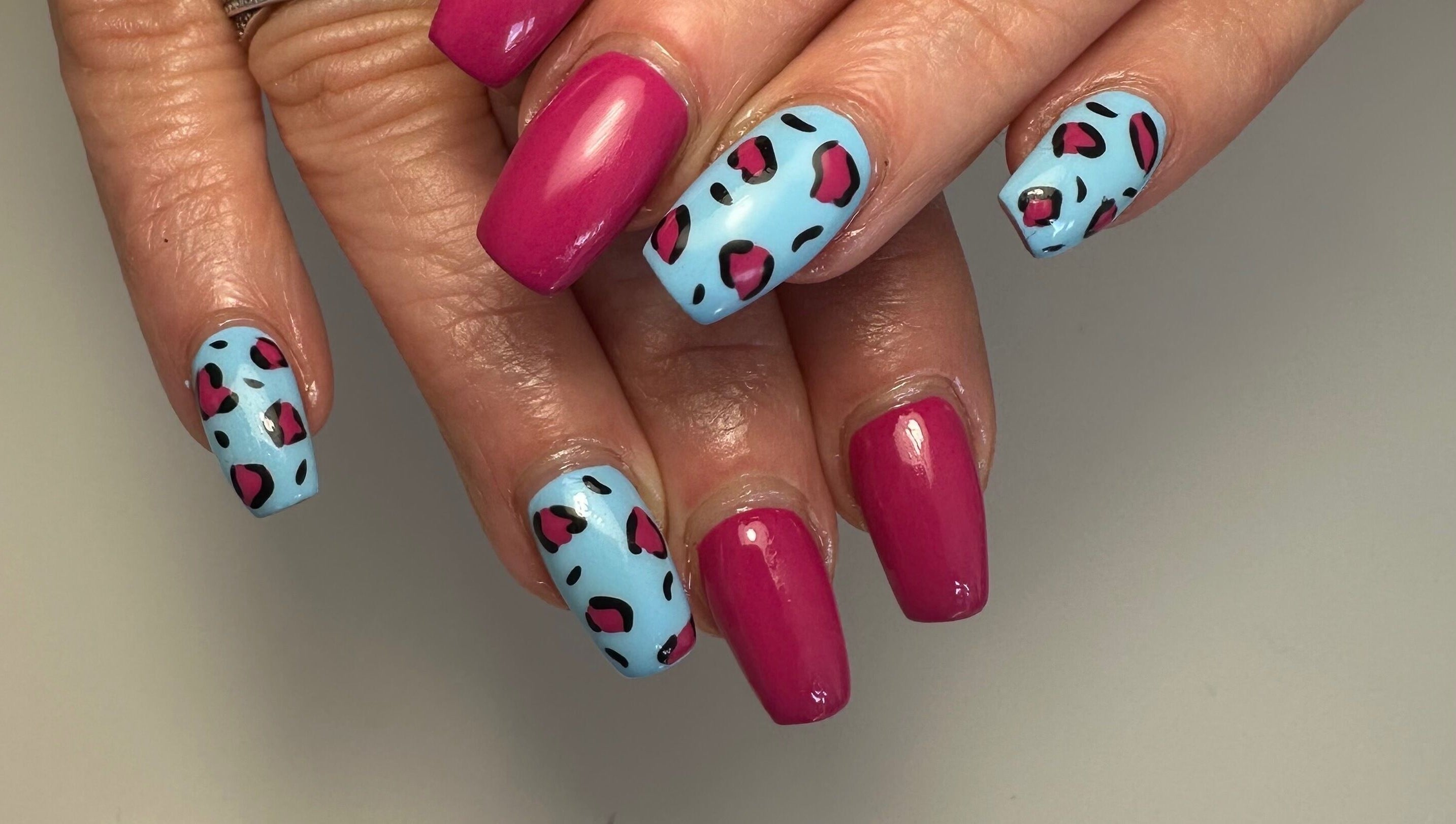 Vibrant pink and blue nail art at A Touch of Colour, Eastleigh, England, GB.