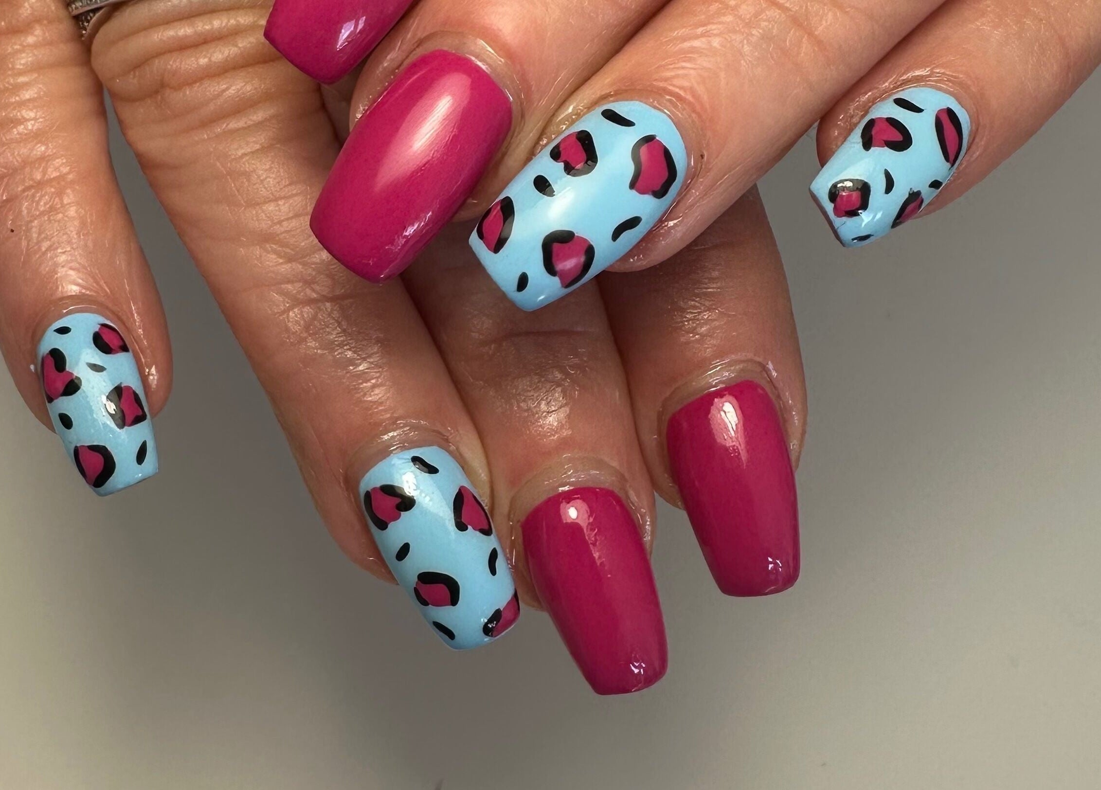 Vibrant pink and blue nail art at A Touch of Colour, Eastleigh, England, GB.
