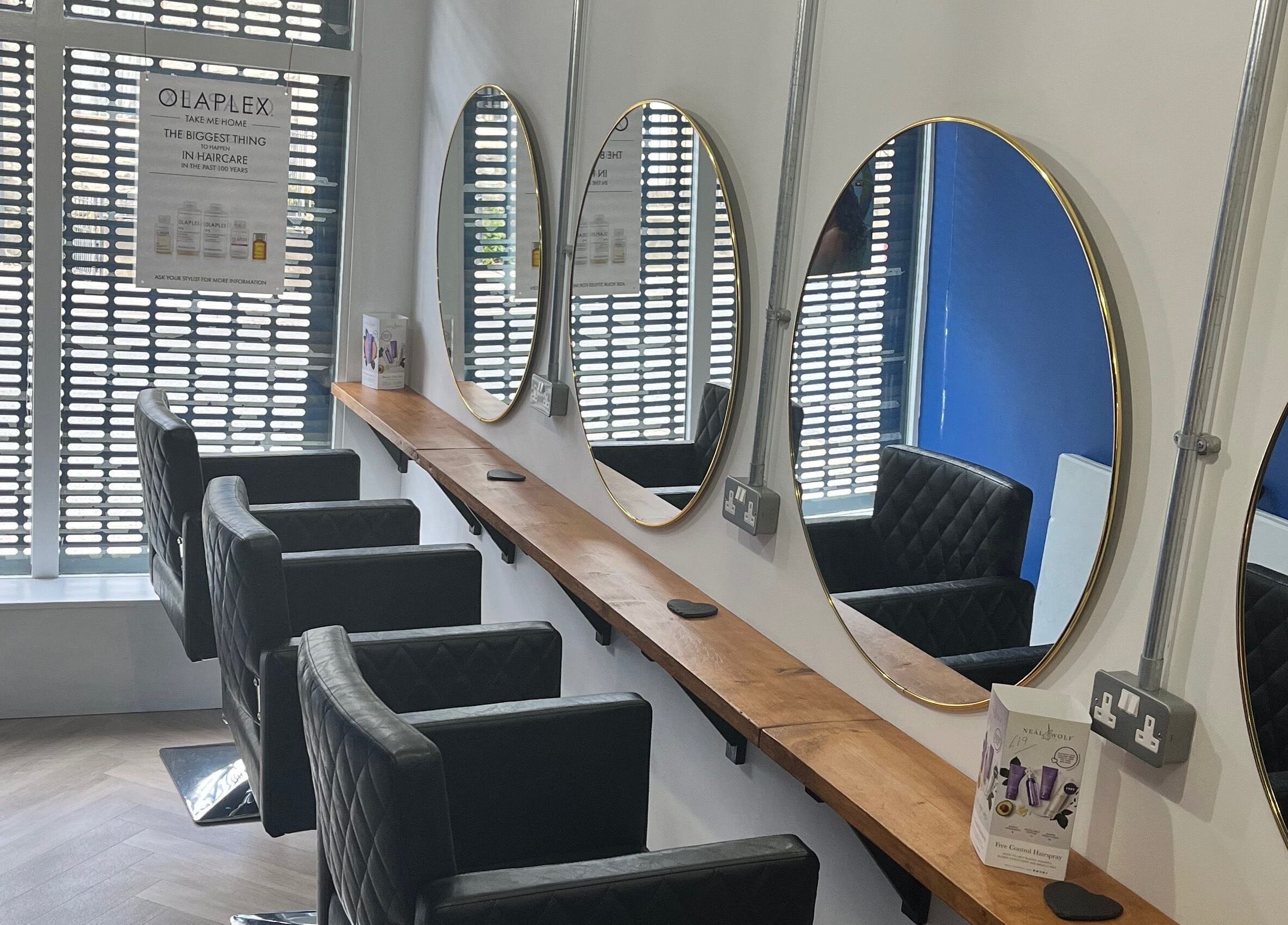 Stylish salon interior with round mirrors at E.L.M Academy, Bacup, England, GB.