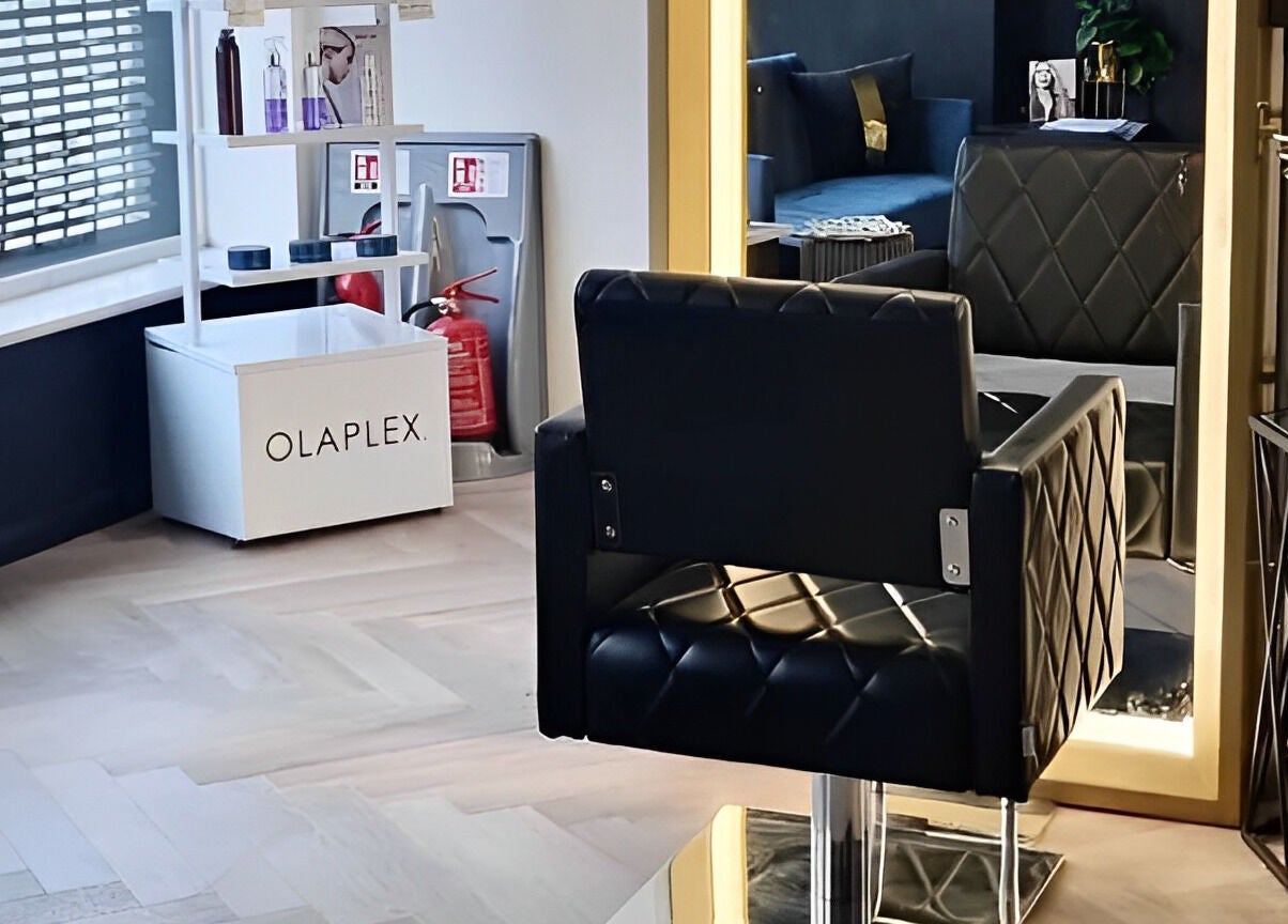 Stylish salon interior at E.L.M Academy, Bacup, England, GB featuring elegant chair and Olaplex products.
