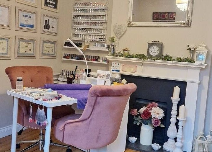 Cozy manicure station at Radiant Rose Beauty Room, Salisbury, England, with plush chairs and nail polish display.