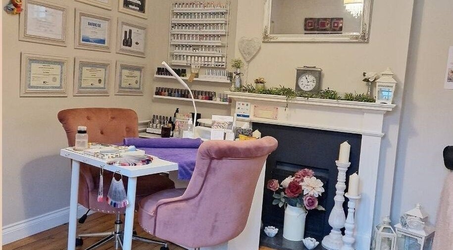 Cozy manicure station at Radiant Rose Beauty Room, Salisbury, England, with plush chairs and nail polish display.