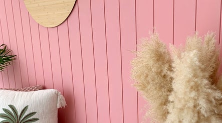 A pastel pink wall with pampas grass decor at Palm Beauty Noosa, Noosaville, Queensland, AU.