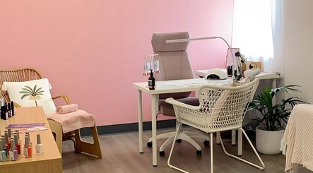 Cozy nail care station at Palm Beauty Noosa, Noosaville, Queensland, AU with pink walls and wicker decor.