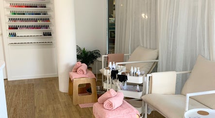 Relaxing nail care area at Palm Beauty Noosa, Noosaville, Queensland, AU, with cozy chairs and vibrant polish display.