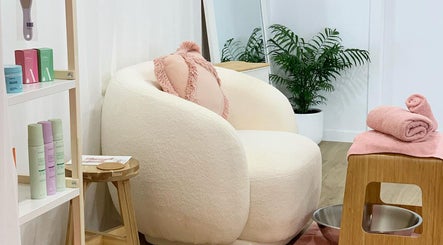 Chic relaxation space at Palm Beauty Noosa, Noosaville, Queensland, AU, with plush chair and calming decor.