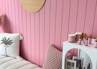 Serene pink interior at Palm Beauty Noosa in Noosaville, Queensland, AU, featuring plush cushions and skincare products.