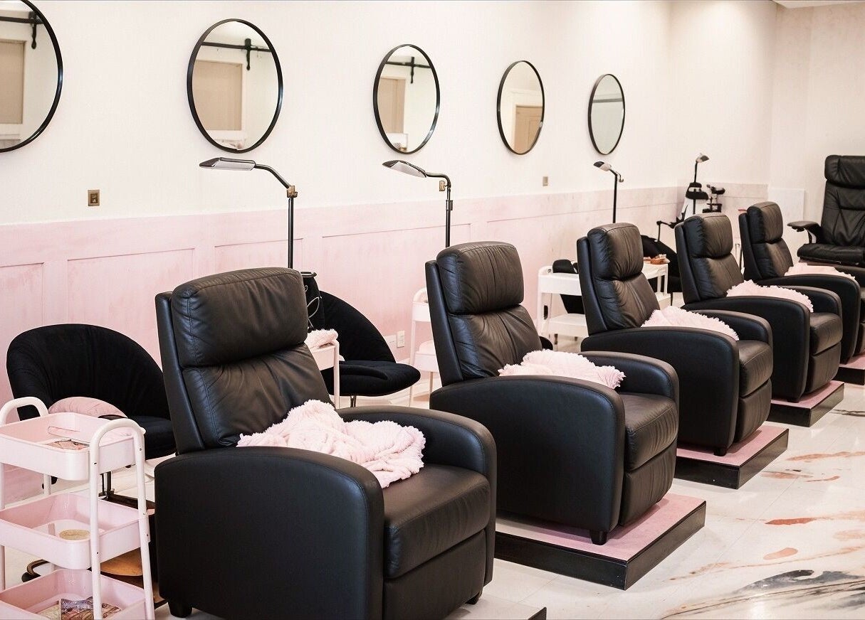 Luxurious seating at Babe Cave Studio, River Oaks, Texas, US, featuring sleek black chairs and pink accents.