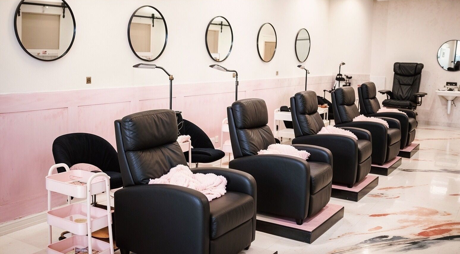 Luxurious seating at Babe Cave Studio, River Oaks, Texas, US, featuring sleek black chairs and pink accents.