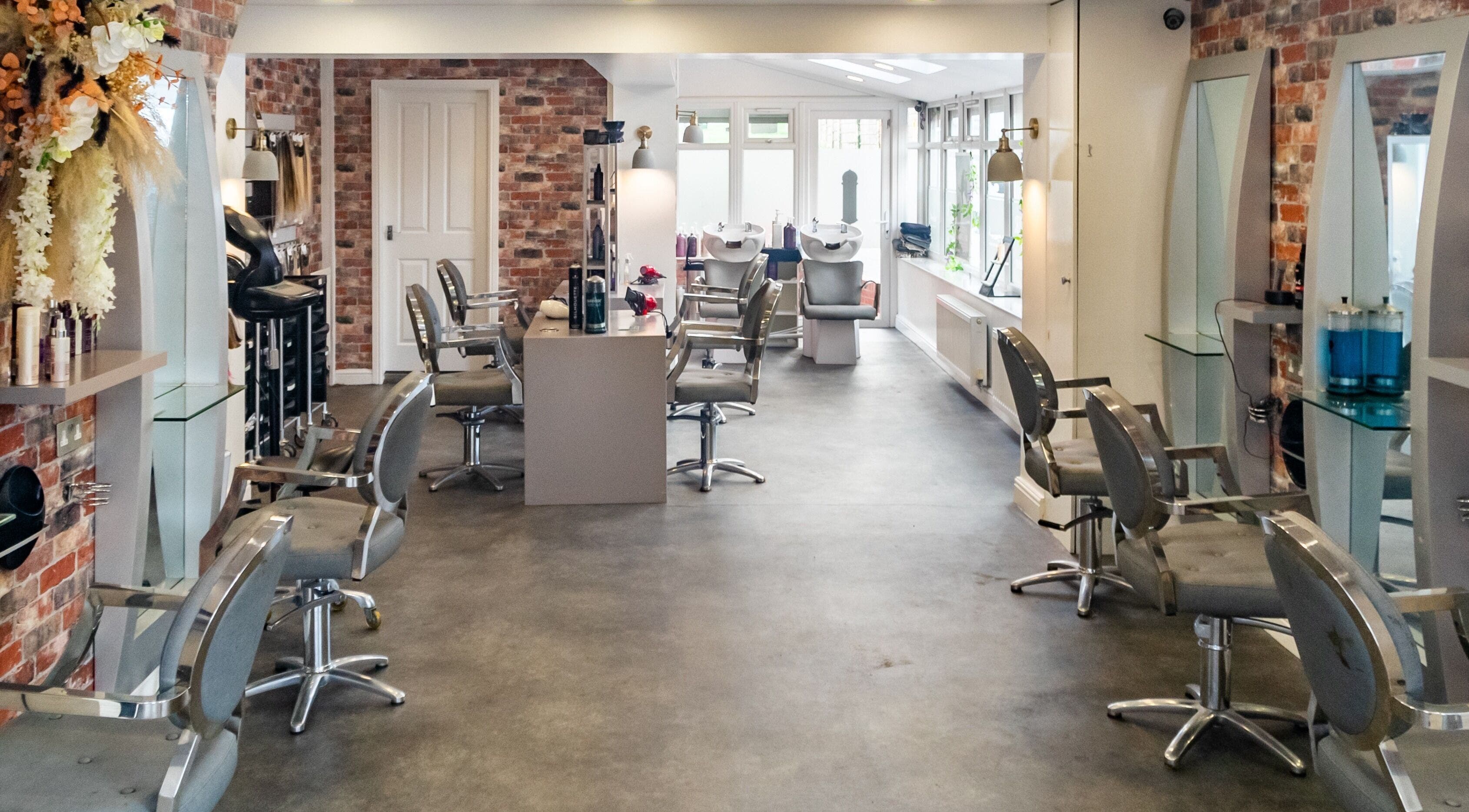Modern salon interior at Hair by Vision Standish, Standish, England, GB with stylish chairs and mirrors.