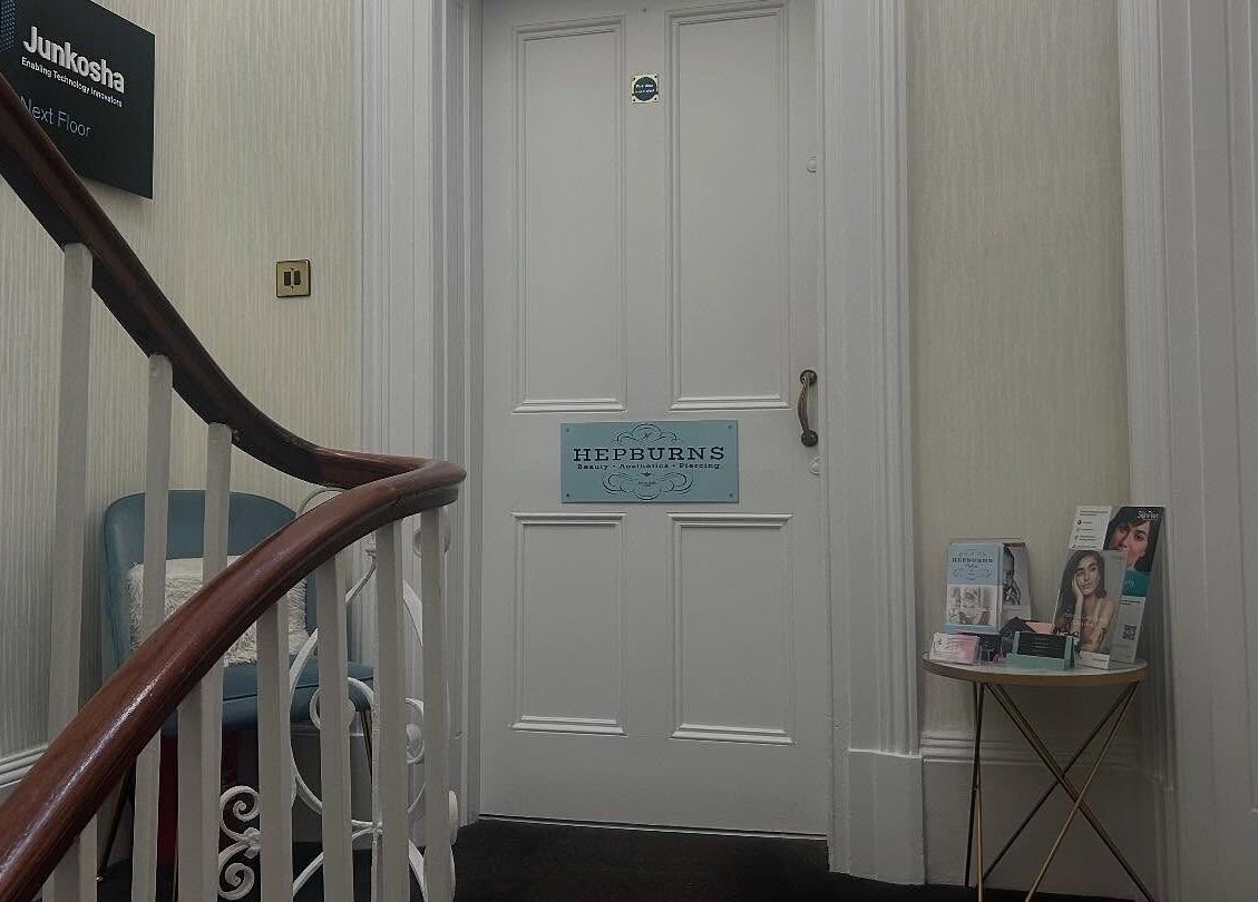 Entrance to Hepburns on the Prom in Cheltenham, England, GB with charming stairway and brochures.