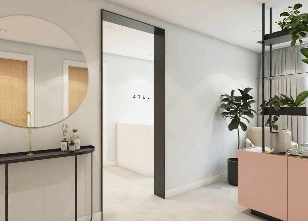 Modern, welcoming entrance at Beata Durtan at Atelier Clinic, Egham. Elegant decor, plants, and a stylish mirror.