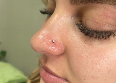Nose piercing at Cassandra Jade’s Collective in Alberton, Gauteng, ZA. Close-up of a shiny nose stud.