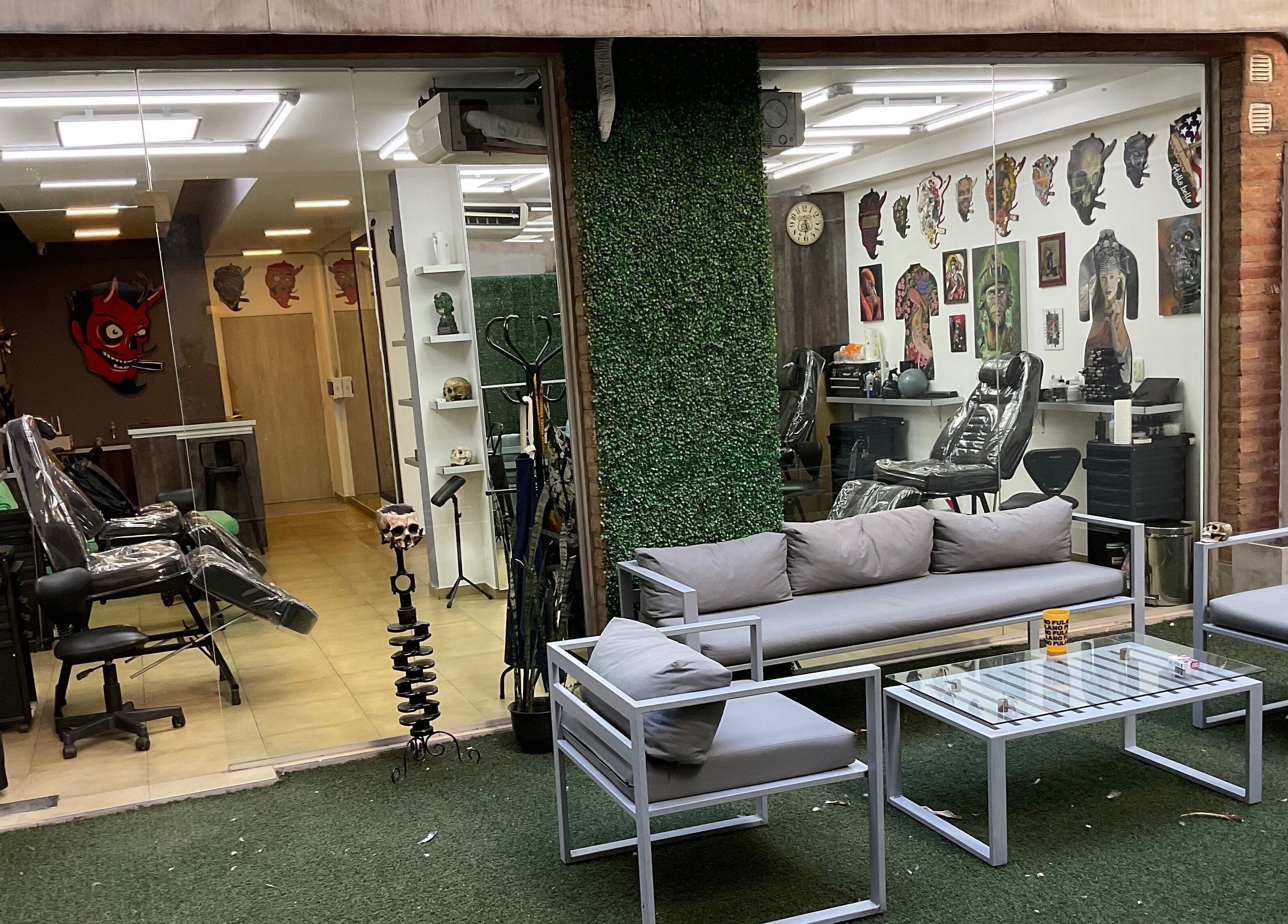 Interior del Buena Vida Tattoo Studio en Córdoba, Córdoba, AR, mostrando sillas y obras de arte en las paredes.