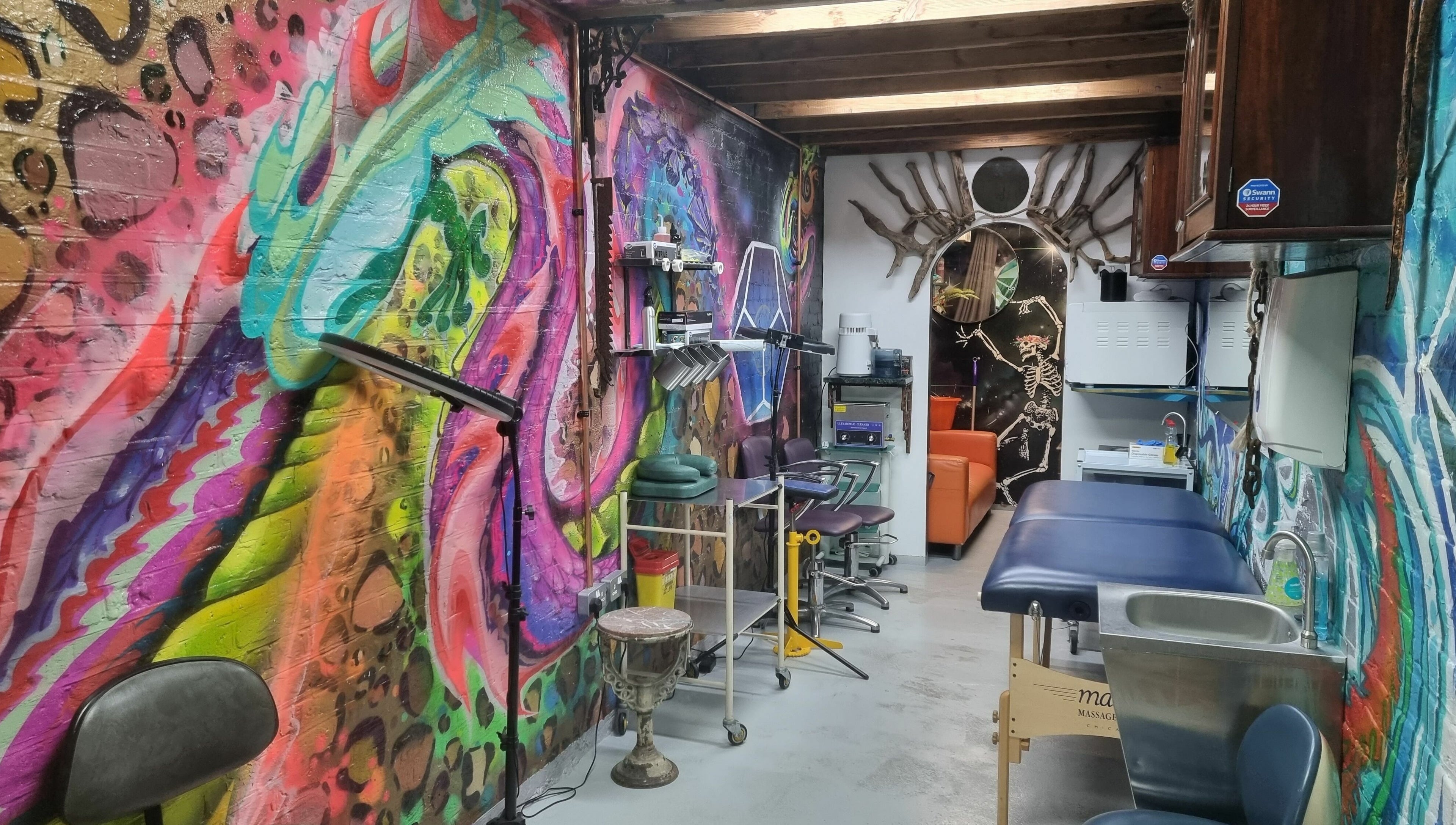 Colorful interior of Studio Gaia London, located in London, England, GB, showcasing vibrant graffiti art and wellness setup.