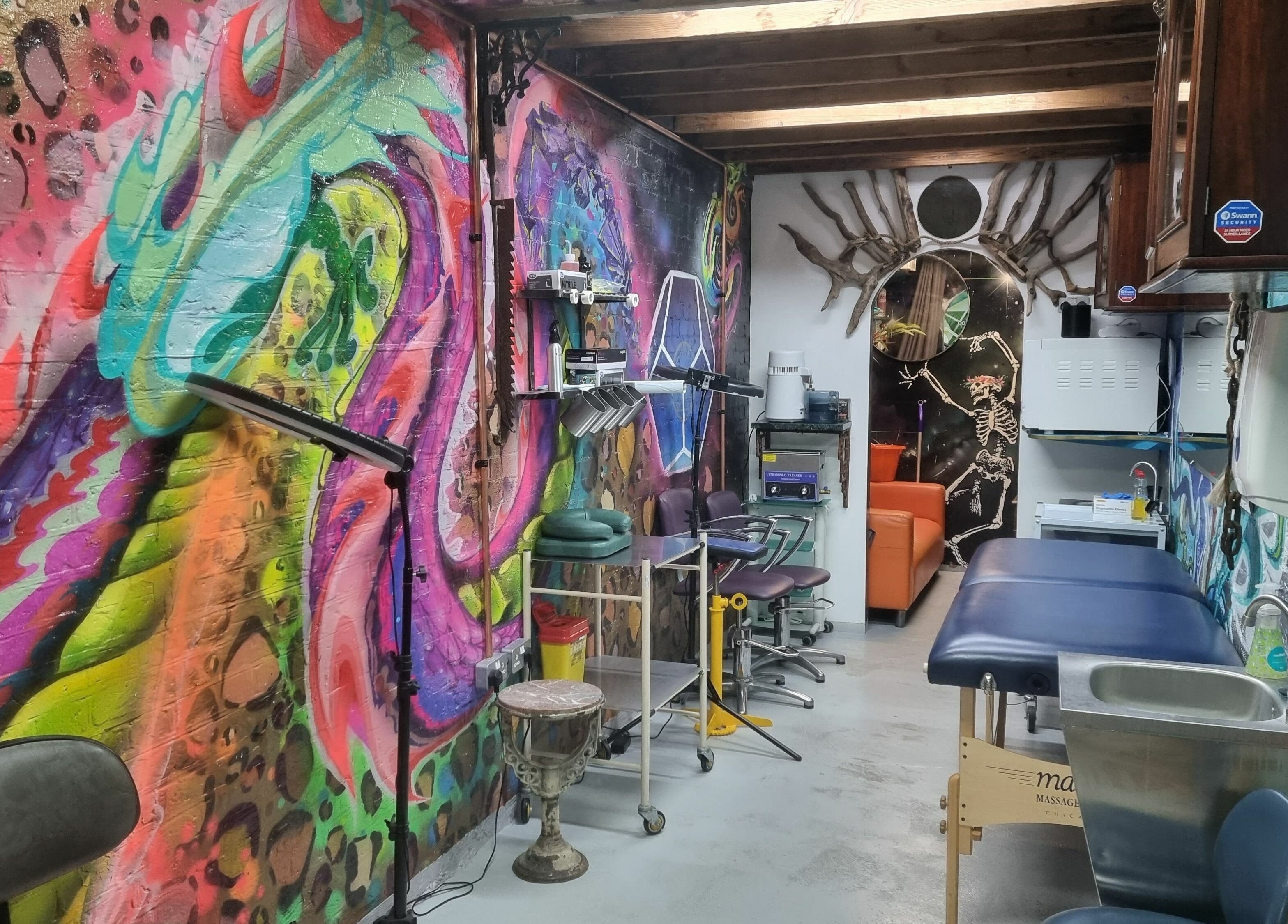 Colorful interior of Studio Gaia London, located in London, England, GB, showcasing vibrant graffiti art and wellness setup.