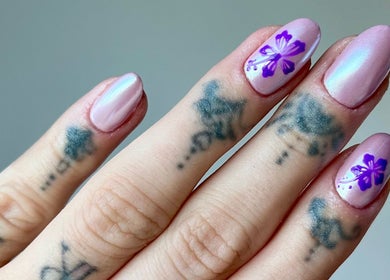 Hand with pink and purple floral nails at Kayley Diane Nails, Colchester, England, GB.