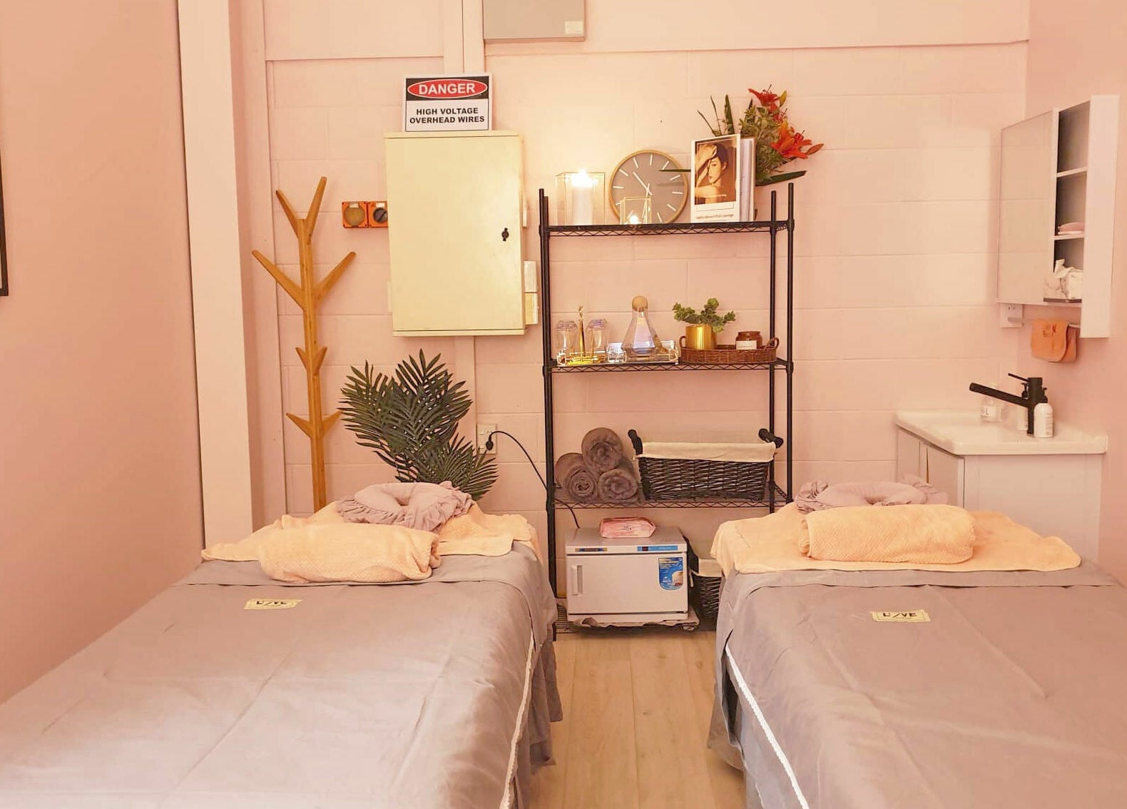 Tranquil treatment room at Hello Beautiful Lounge - Hastings, NZ, with massage tables and soothing decor.