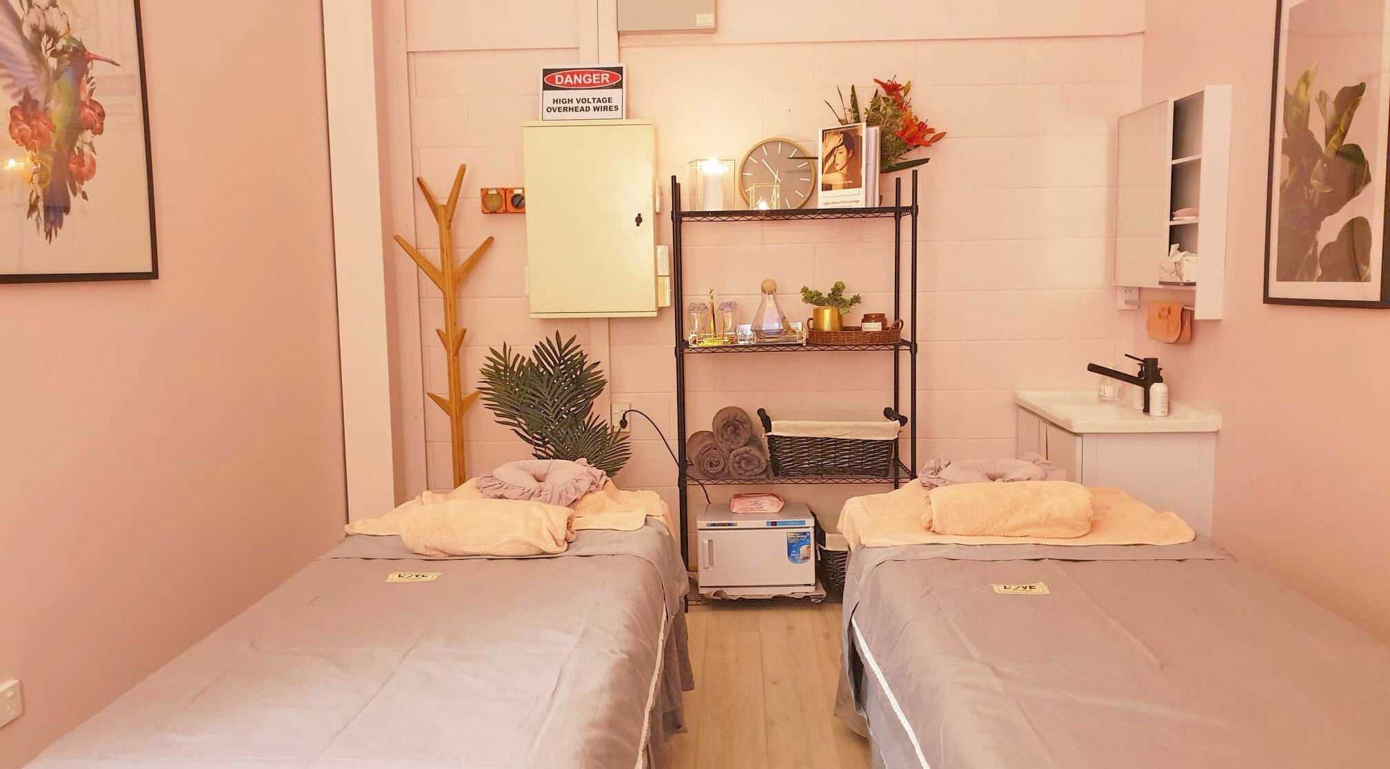 Tranquil treatment room at Hello Beautiful Lounge - Hastings, NZ, with massage tables and soothing decor.