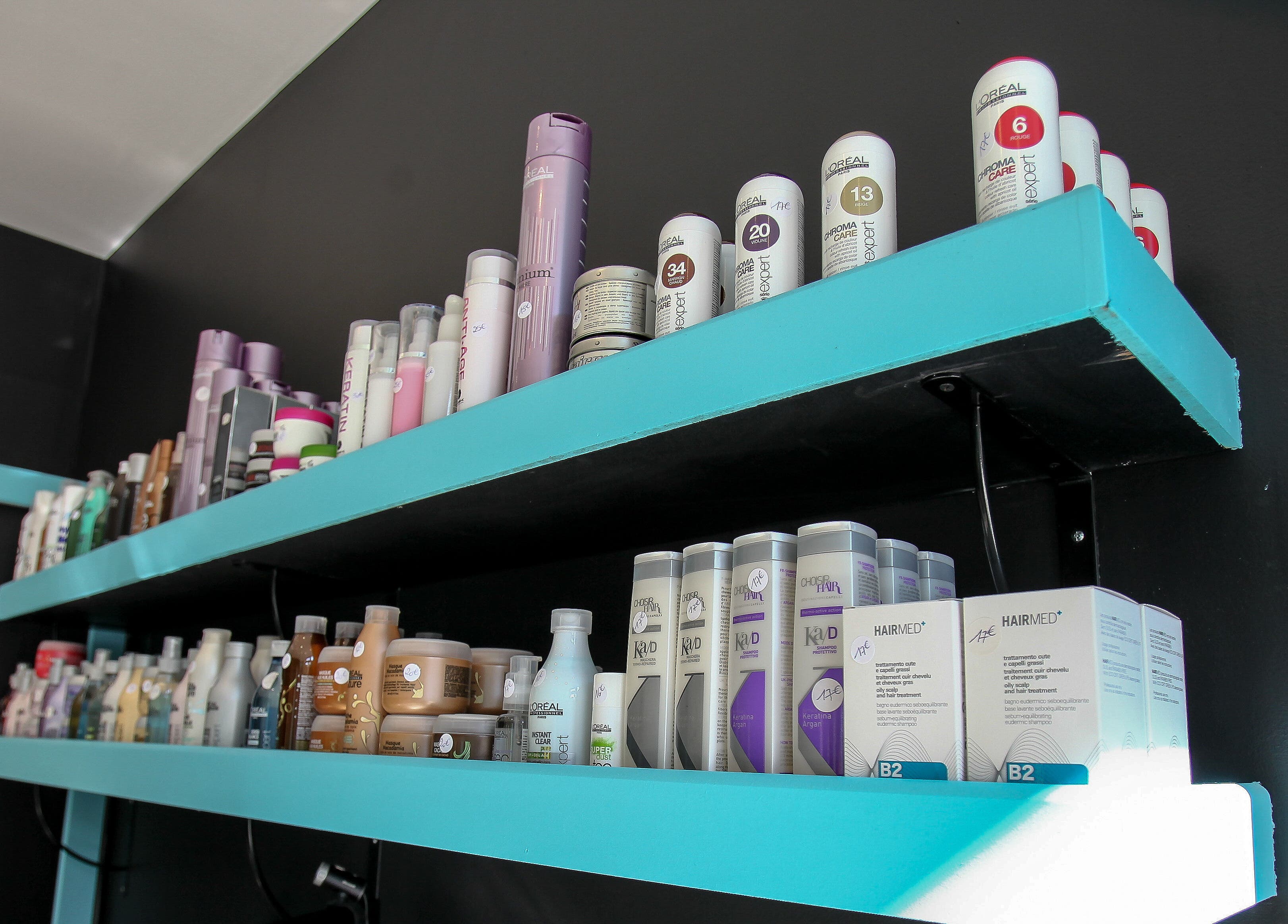 Produits capillaires sur des étagères bleues à Extensions VIP Paris, Paris, Île-de-France, FR.