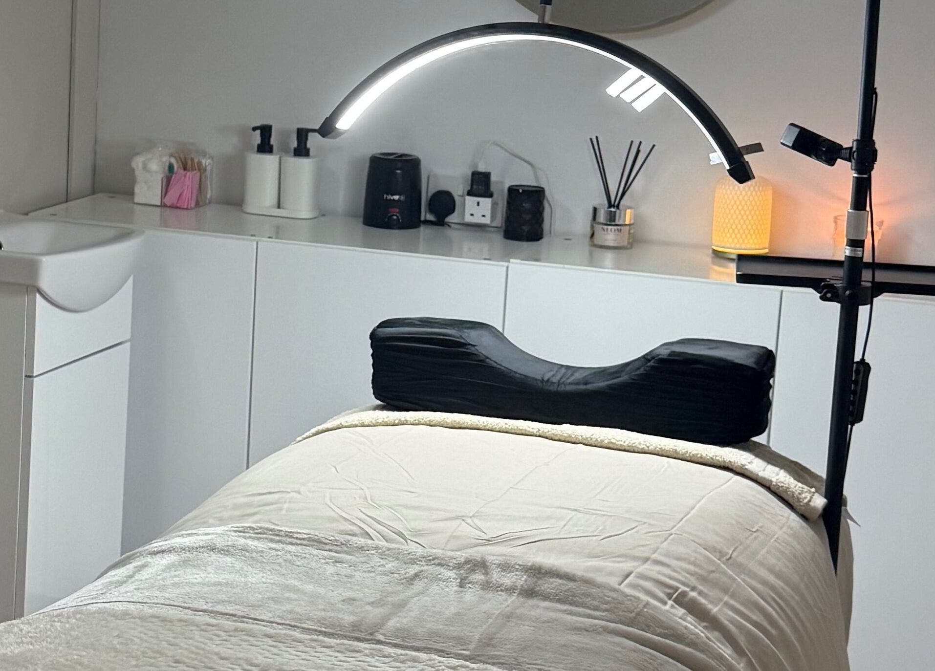 Relaxing treatment room at Belles Beauty, Mirfield, England, GB with massage table and ambient lighting.