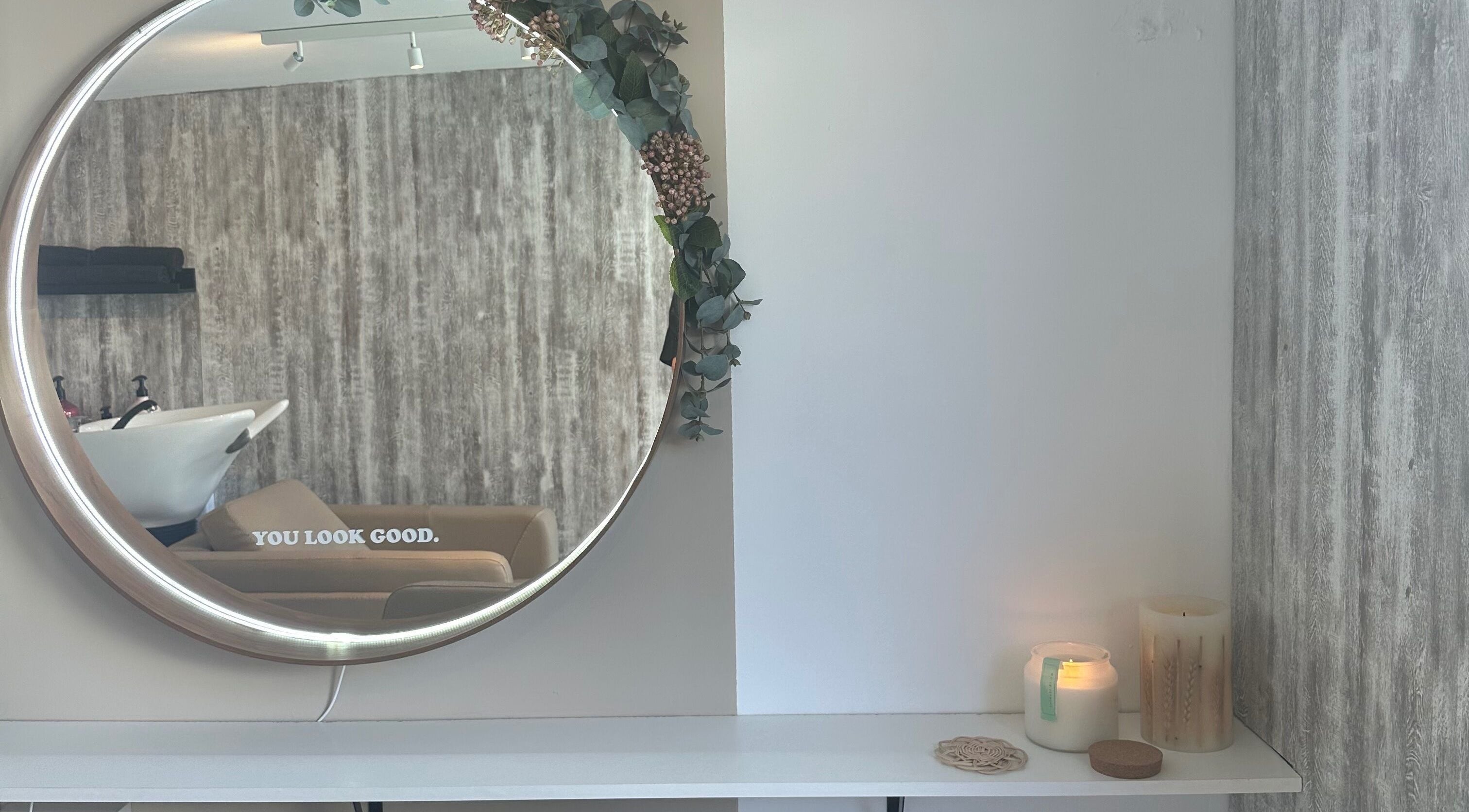 Elegant mirror with floral decor at Maddie.Alix.Hair, Ilkley, England, GB creates a calming salon ambiance.
