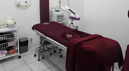 Elegant treatment room at Pinsela Aesthetic in Bali, Bali, ID with burgundy decor and modern equipment.