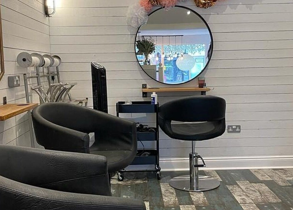 Modern salon interior at Prettyme Hair and Beauty, Derby, England, GB. Features stylish seating and decor.