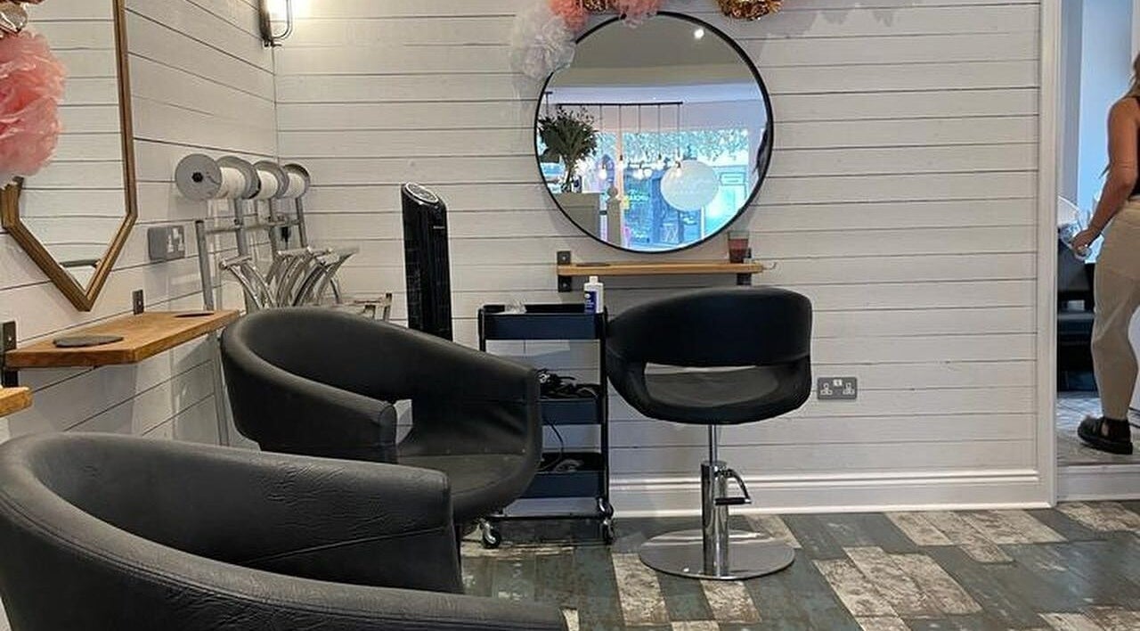 Modern salon interior at Prettyme Hair and Beauty, Derby, England, GB. Features stylish seating and decor.