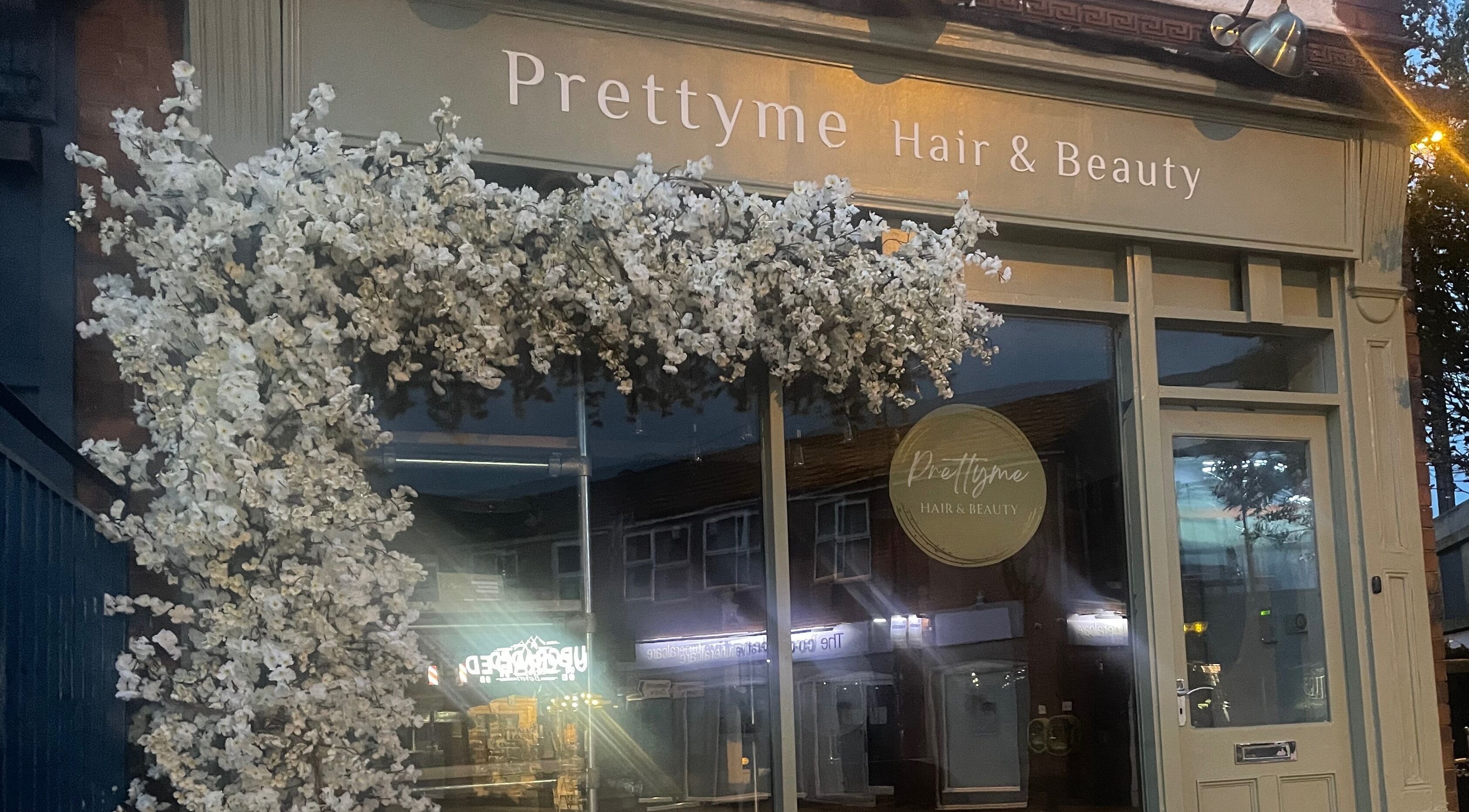 Prettyme Hair and Beauty's elegant facade in Derby, England, GB, adorned with white blossoms.