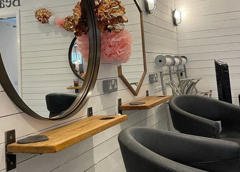 Stylish interior at Prettyme Hair and Beauty, Derby, England featuring elegant mirrors and chairs.