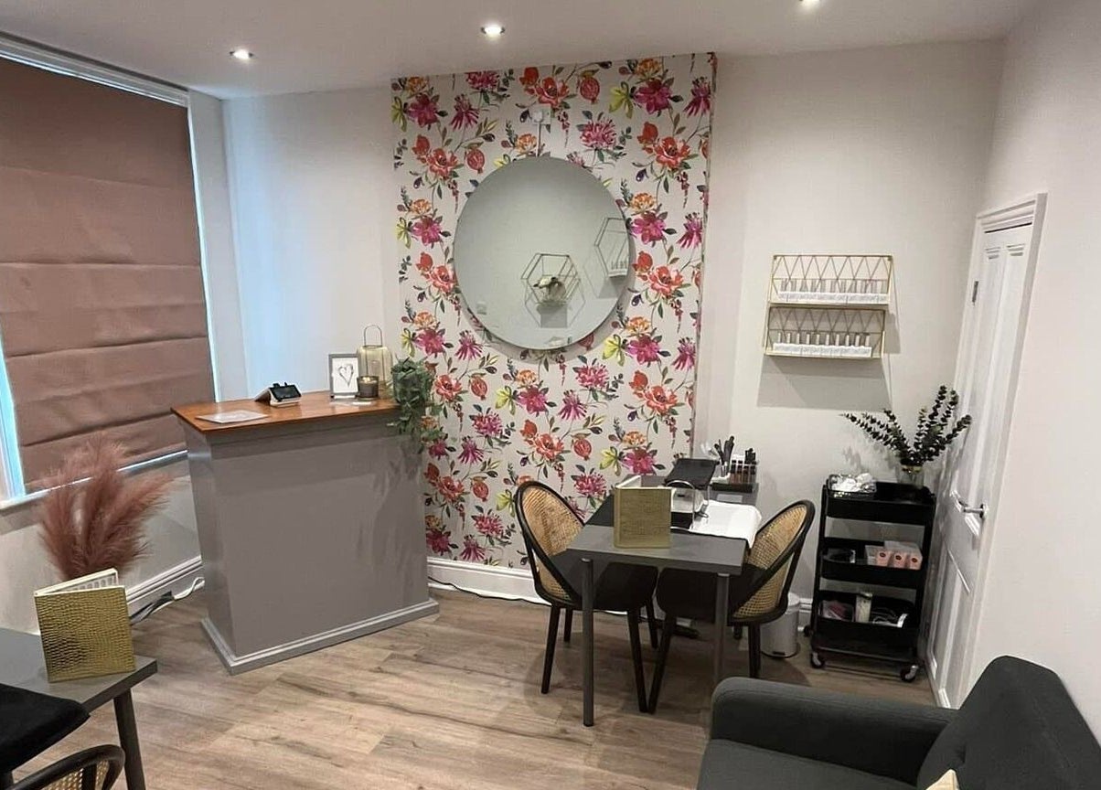 Chic salon interior at Prettyme Hair and Beauty, Derby, England, GB, featuring floral wall and modern decor.
