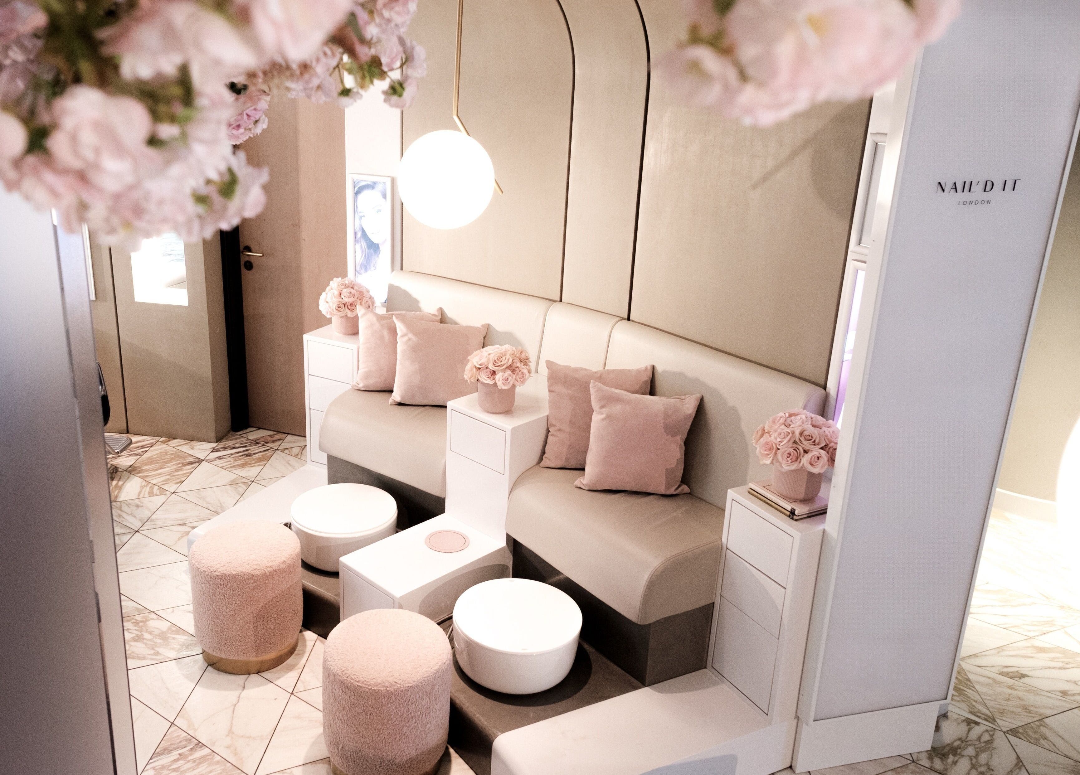 Elegant seating area at Nail'd It Birmingham, featuring pink decor and plush pillows in Birmingham, England, GB.