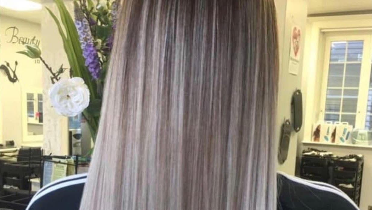 Elegant highlighted hairstyle at Hair By Lorna Oldroyd, Ossett, England, GB salon with floral decor.