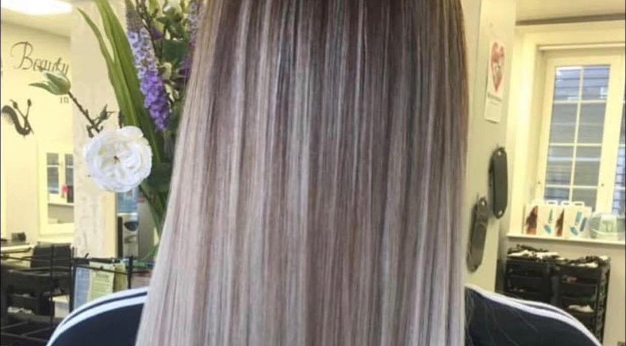 Elegant highlighted hairstyle at Hair By Lorna Oldroyd, Ossett, England, GB salon with floral decor.