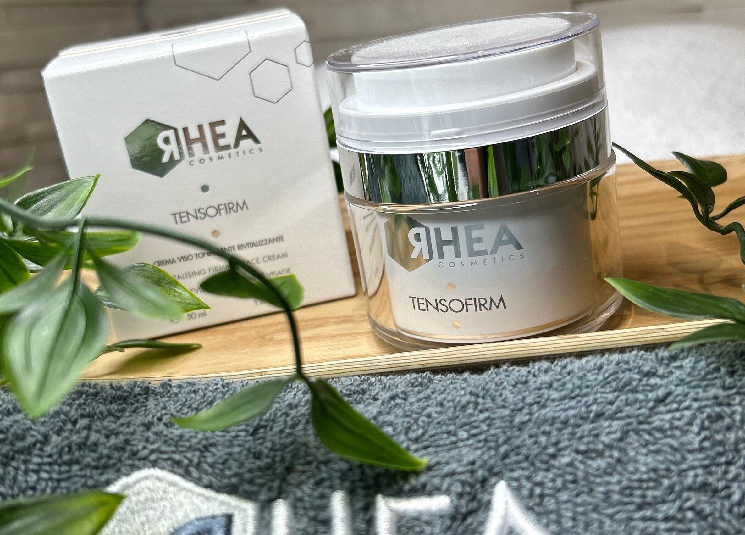 Crème RHEA TensoFirm exposée à Douceurs Pour Soi, Rolle, Vaud, CH, entourée de feuillage luxuriant.