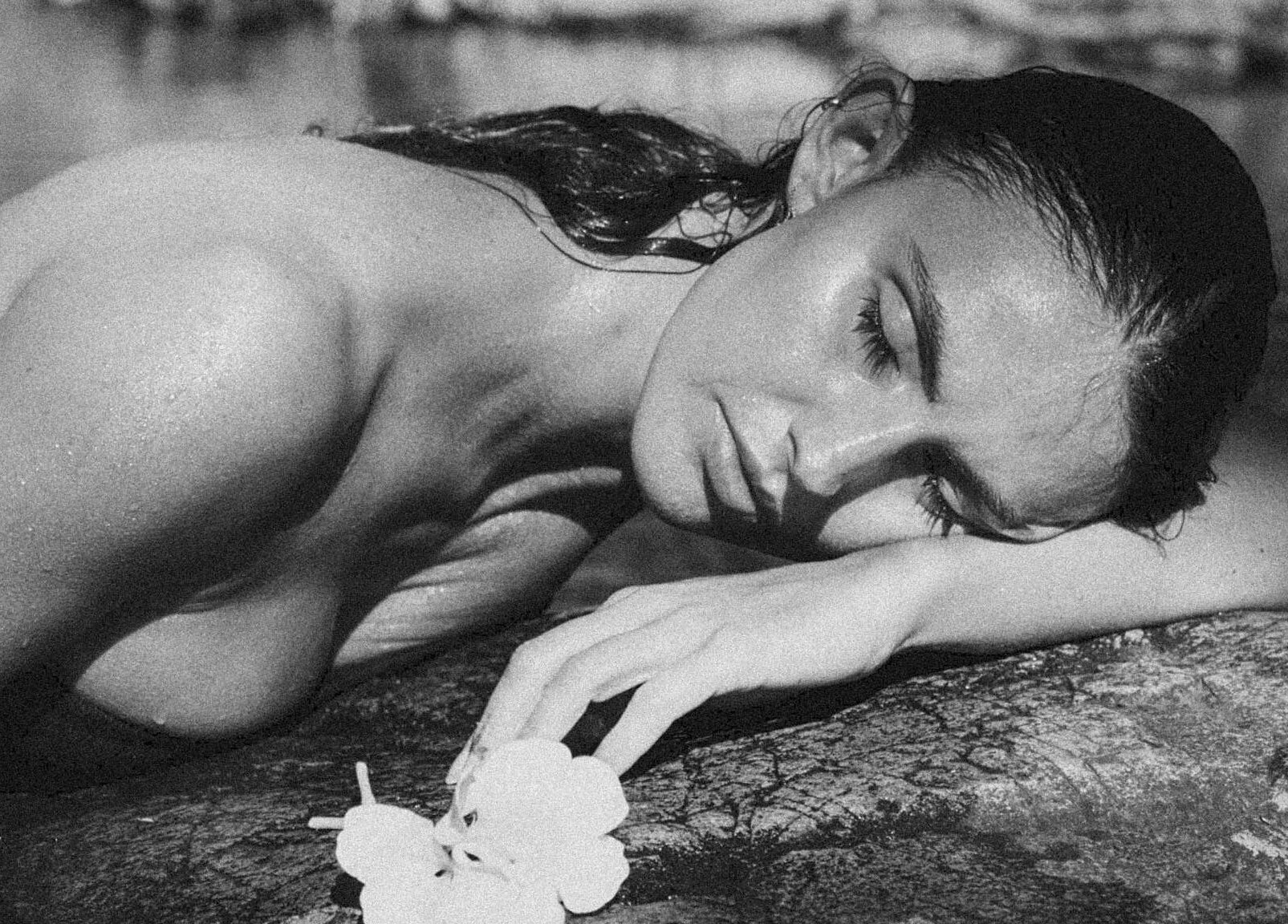 Relaxed woman with flower at Soulflower Studio, Sawtell, New South Wales, AU, embodying tranquility and natural beauty.