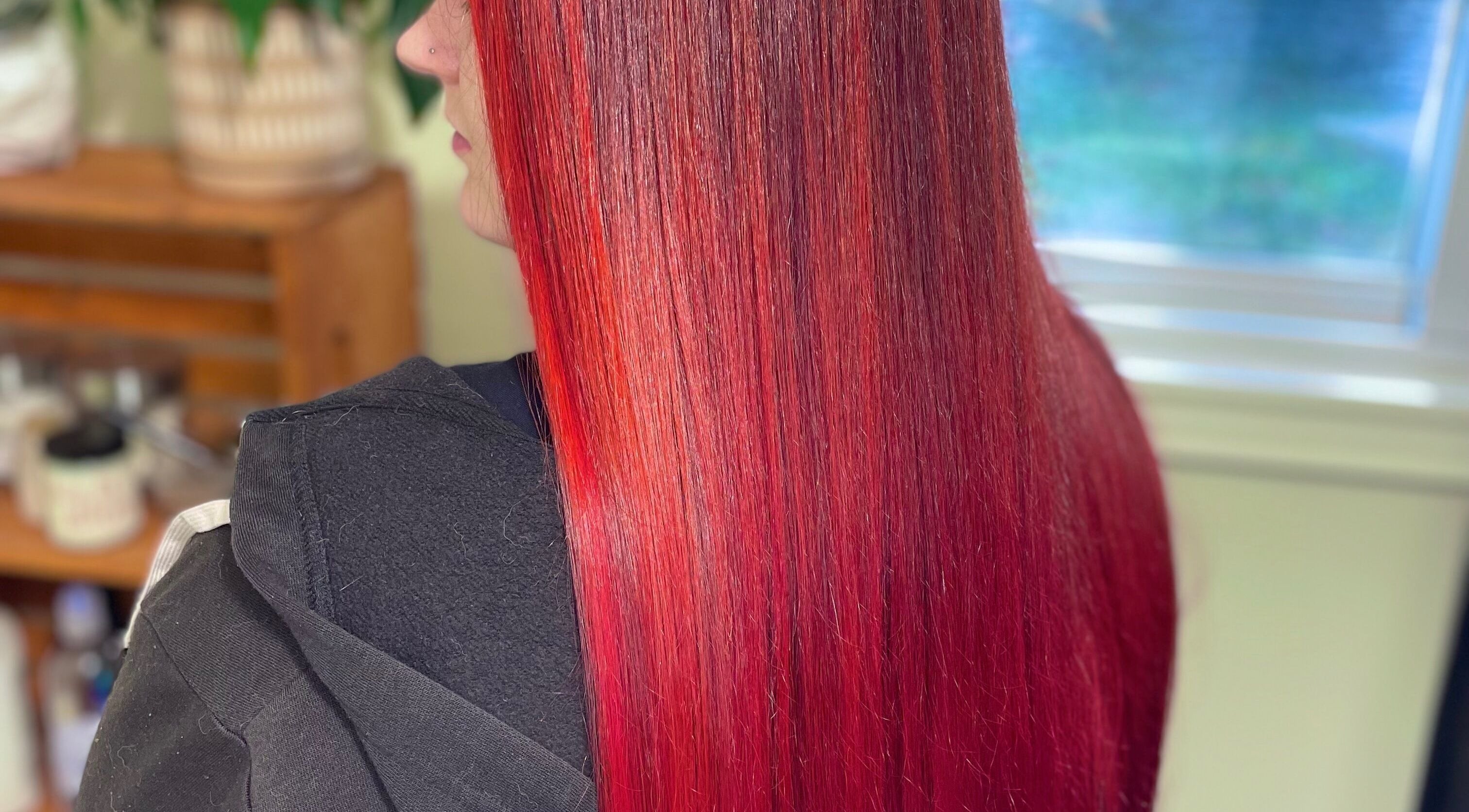 Vibrant red hair styled at Modcrown Creations, Oshawa, Ontario, CA showcasing sleek and glossy finish.