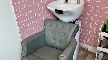 Elegant wash station at Hair by Melissa Victoria in Wickersley, England, GB with pink tiles and plush chair.