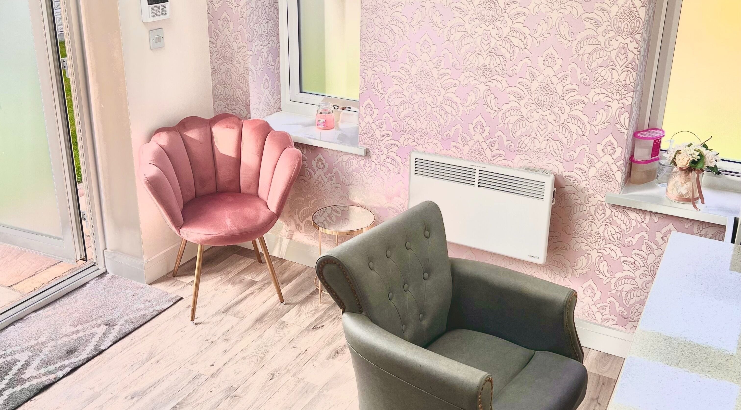 Elegant seating area at Hair by Melissa Victoria in Wickersley, England, GB with pink and grey chairs.