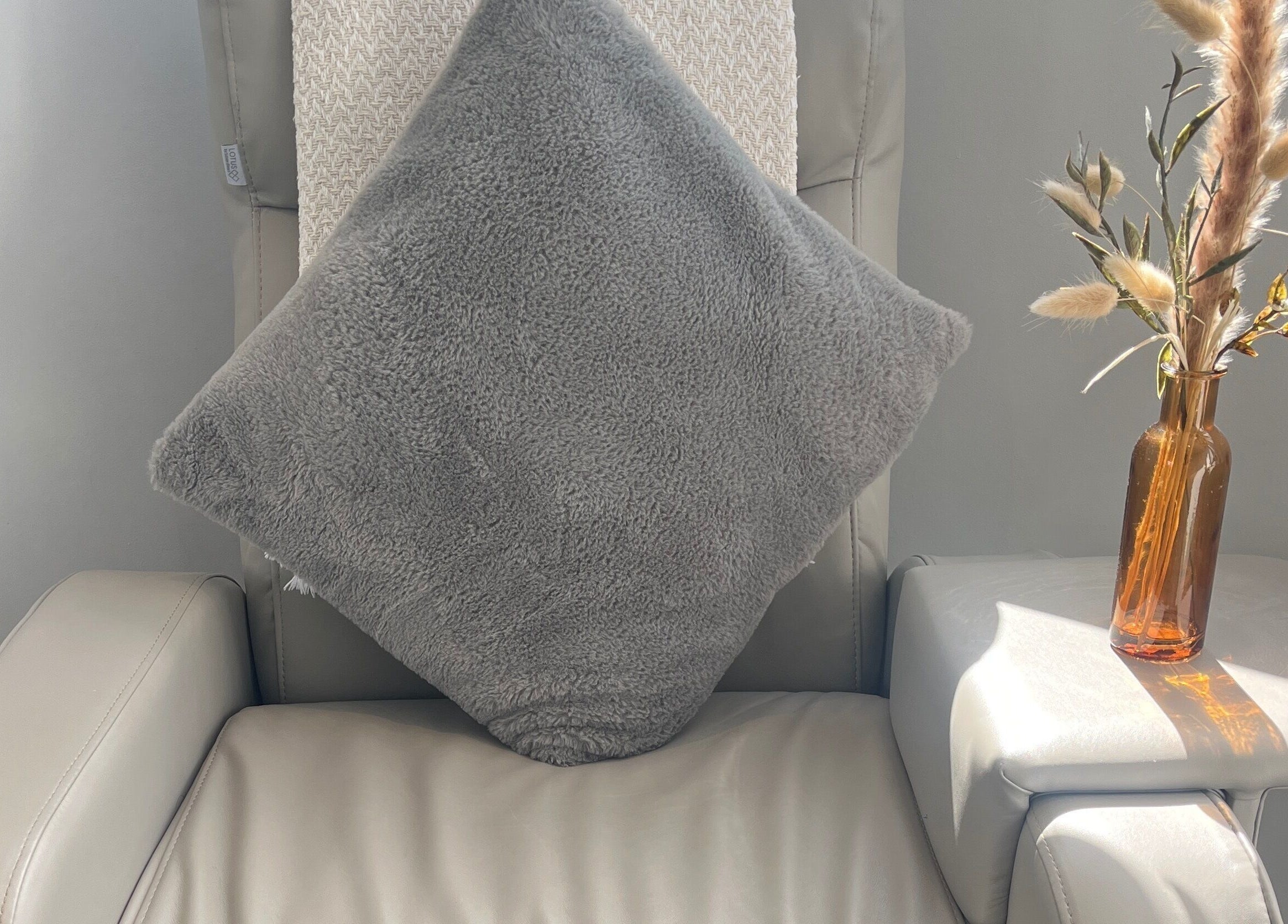 Comfortable chair with plush pillow and vase at Glow House Beauty, Fareham, England, GB.