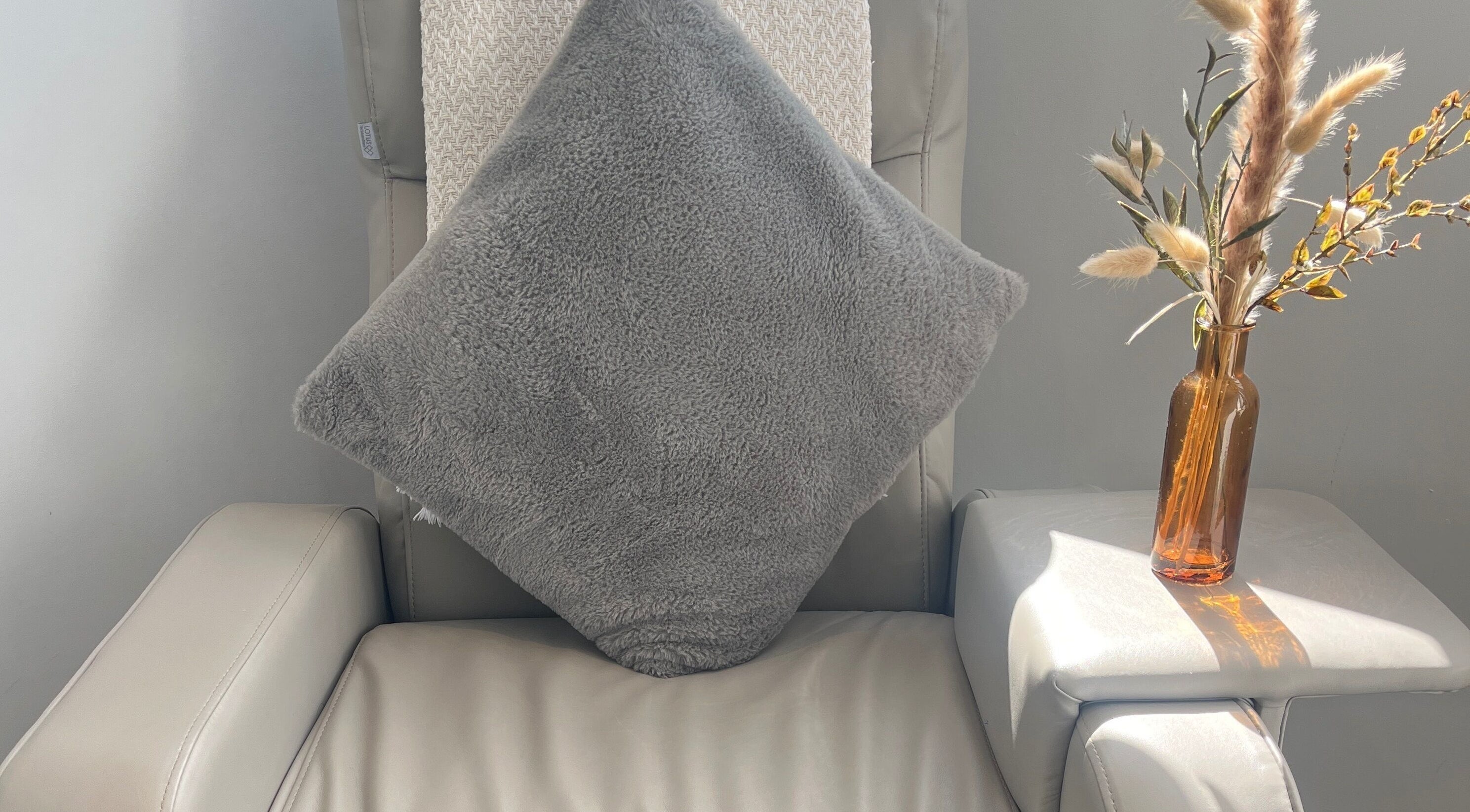 Comfortable chair with plush pillow and vase at Glow House Beauty, Fareham, England, GB.