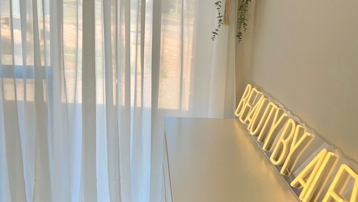 Bright, tranquil interior at Beauty by Alex Yeomans in Whyalla Norrie, South Australia, AU with a glowing sign.