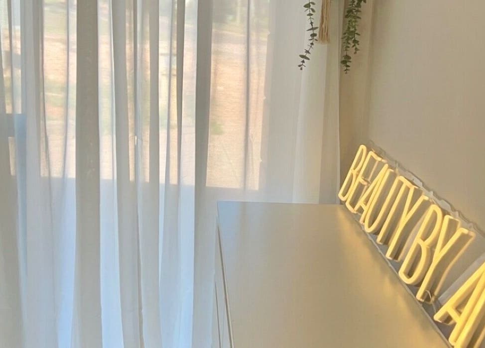 Bright, tranquil interior at Beauty by Alex Yeomans in Whyalla Norrie, South Australia, AU with a glowing sign.